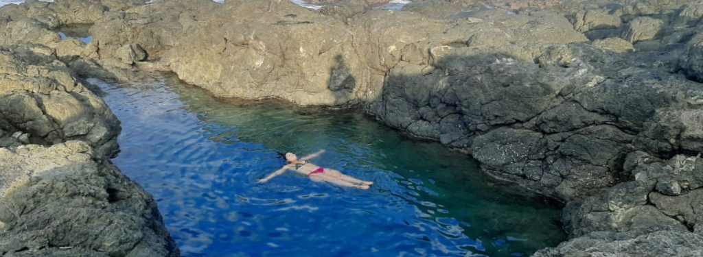 woman floating in the Amor De Mar Tide Pool